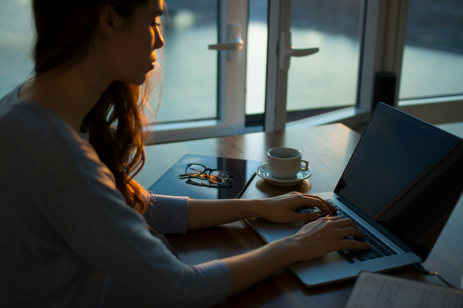 woman sitting beside table using laptop, home insurance