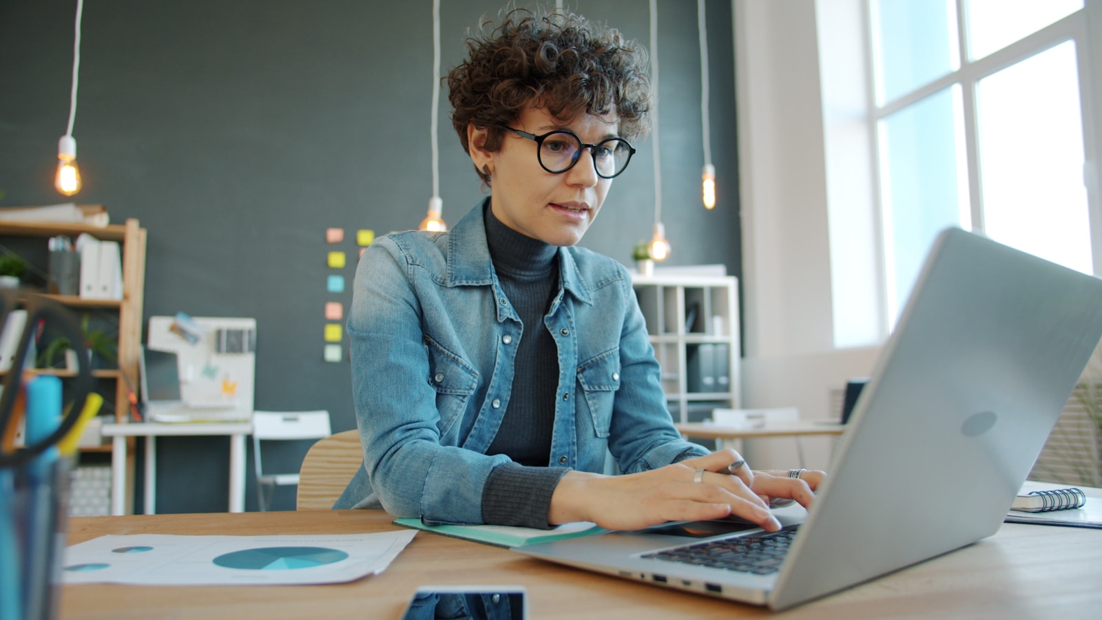 Woman working on a laptop in a modern office, business
